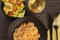 Plate of shrimp risotto, lettuce salad and cherry tomatoes and a glass of white wine Royalty Free Stock Photo