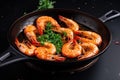 plate of sizzling tiger shrimp prawns in hot pan with garlic and spices