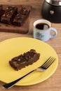 Plate with a slice of brownie, a coffee maker and a cup of coffee