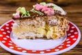 Plate with slice of Kiev cake with cream, nuts and meringue on a wooden table Royalty Free Stock Photo