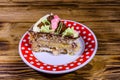 Plate with slice of Kiev cake with cream, nuts and meringue on a wooden table Royalty Free Stock Photo