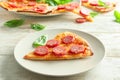 Plate with slice of tasty pizza on wooden table Royalty Free Stock Photo