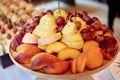 Plate with sliced fruits on servered buffet table at luxury wedding reception, copy space. Catering in restaurant. Royalty Free Stock Photo