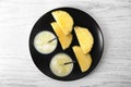 Plate with sliced pineapple and glasses of fresh juice on white wooden table Royalty Free Stock Photo