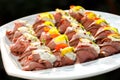 Plate of sliced, rolled and garnished roast beef canapes. On black background.