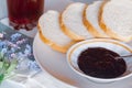 Plate with slices of bun and a blackcurrant jam socket