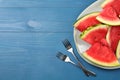 Plate with slices of juicy watermelon on blue wooden table, top view. Space for text Royalty Free Stock Photo