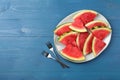 Plate with slices of juicy watermelon on blue wooden table, top view. Space for text Royalty Free Stock Photo