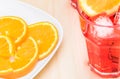 Plate of slices oranges near glass of spritz aperitif aperol cocktail with orange slices