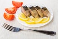 Plate with slices of smoked mackerel, lemon, pieces of tomato Royalty Free Stock Photo