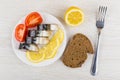 Plate with slices of smoked mackerel, lemon, tomato, bread Royalty Free Stock Photo