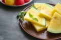 Plate with slices of yellow watermelon on dark table Royalty Free Stock Photo