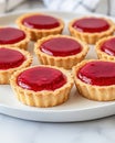 A plate of small tart desserts with a glossy red fruit topping Royalty Free Stock Photo