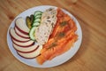 Plate with smoked salmon, slices of bread, fresh cucumber, cornichons and cheese on a wooden table Royalty Free Stock Photo