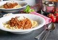 A plate of spaghetti bolognese with rasped parmesan cheese