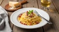 A plate of spaghetti carbonara with cheese and bacon on a wooden table Royalty Free Stock Photo