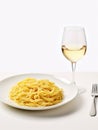 Plate of spaghetti pasta and glass of white wine. Royalty Free Stock Photo