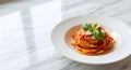 Plate of Spaghetti Pasta with Tomato Sauce and Fresh Basil on White Marble Surface Royalty Free Stock Photo