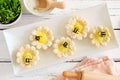 Plate of spring flower shaped lemon tarts with bees, top view scene against a white wood background Royalty Free Stock Photo