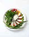 Plate with spring salad. Assorted fresh herbs and vegetables with soft cheese isolated on white background