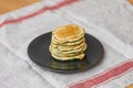 Plate with stack of fresh fried pancakes on table