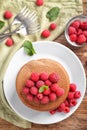 Plate with stack of tasty chocolate pancakes and raspberries on wooden table Royalty Free Stock Photo