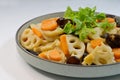 Plate of stir-fried lotus roots, carrots, wood ear fungus, garnished with Chinese parsley