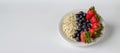 Plate with strawberries blueberries and oats white background