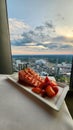 A plate of strawberry short cake with sliced strawberries on a table with a white tablecloth and a gorgeous view of the city Royalty Free Stock Photo