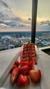 A plate of strawberry short cake with sliced strawberries on a table with a white tablecloth and a gorgeous view of the city Royalty Free Stock Photo