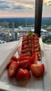 A plate of strawberry short cake with sliced strawberries on a table with a white tablecloth and a gorgeous view of the city Royalty Free Stock Photo