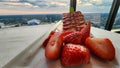A plate of strawberry short cake with sliced strawberries on a table with a white tablecloth and a gorgeous view of the city Royalty Free Stock Photo