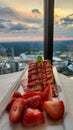 A plate of strawberry short cake with sliced strawberries on a table with a white tablecloth and a gorgeous view of the city Royalty Free Stock Photo