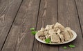 Plate with sunflower halva decorated with mint leaves on a dark wooden table, selective focus. Copy space