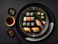 a plate of sushi with chopsticks and a cup of tea on a black tablecloth with a gold trim around the Royalty Free Stock Photo