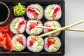 The plate of sushi with soy sauce, wasabi and chopsticks