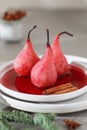 Plate with sweet poached pears in red wine on light background. Royalty Free Stock Photo