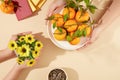 A plate of tangerines, a vase of sunflowers, a bowl of dried sunflower seeds and lucky money envelopes stand out against the beige