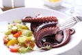 Plate with tasty boiled octopus tentacles and salad on table, closeup Royalty Free Stock Photo