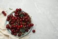 Plate of tasty cherries and fabric on grey marble table, space for text Royalty Free Stock Photo