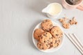 Plate with tasty chocolate chip cookies and cup of coffee on gray background, top view Royalty Free Stock Photo