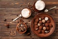 Plate with tasty chocolate truffles and cups of cappuccino on wooden table Royalty Free Stock Photo