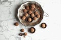 Plate and tasty chocolate truffles on marble background Royalty Free Stock Photo