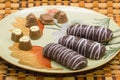 Plate with tasty cookies and chocolates on a good background