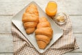 Plate with tasty croissants and glass of orange juice on wooden table Royalty Free Stock Photo