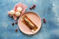 Plate with tasty eclair and macarons on color table Royalty Free Stock Photo