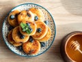 Plate with tasty fluffy pancakes with blueberries, honey