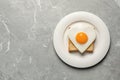 Plate with tasty fried egg in shape of heart and toast on marble table, top view. Space for text Royalty Free Stock Photo