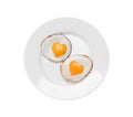 Plate with tasty fried eggs with yolks in shape of heart on white background, top view Royalty Free Stock Photo