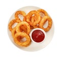 Plate of tasty fried onion rings with ketchup isolated on white, top view Royalty Free Stock Photo